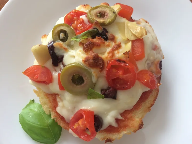 Photo of a glutino gluten free english muffin that has pizza toppings on top and then is toasted 